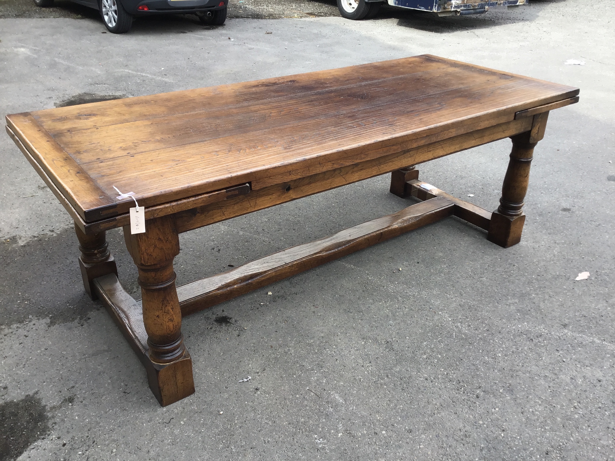 A reproduction 18th century style oak draw leaf refectory dining table with central stretcher, length 300cm extended, width 91cm, height 73cm